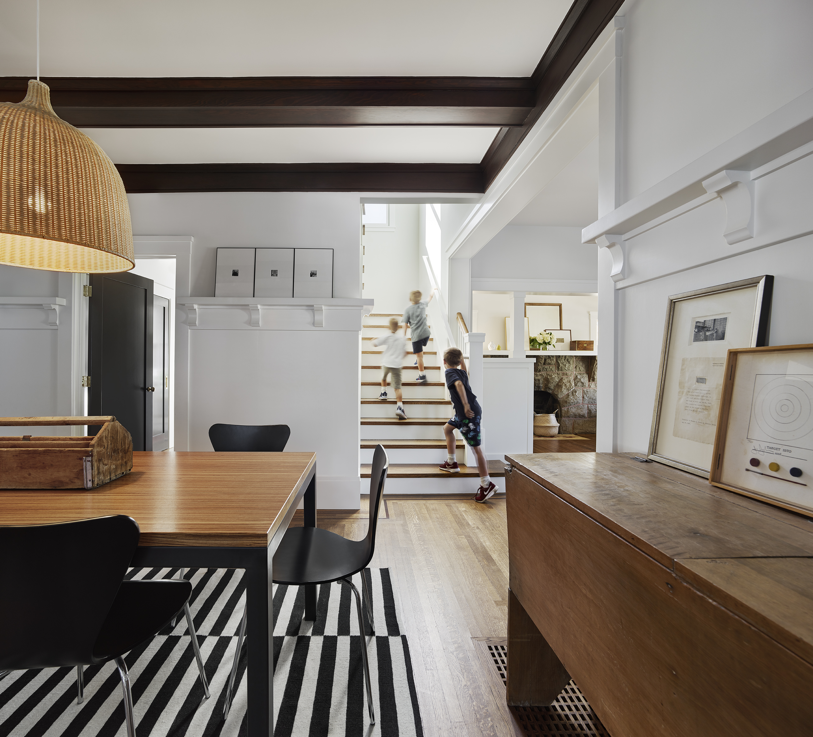 children running up stairs near dining area with black, white, wood in Alameda california