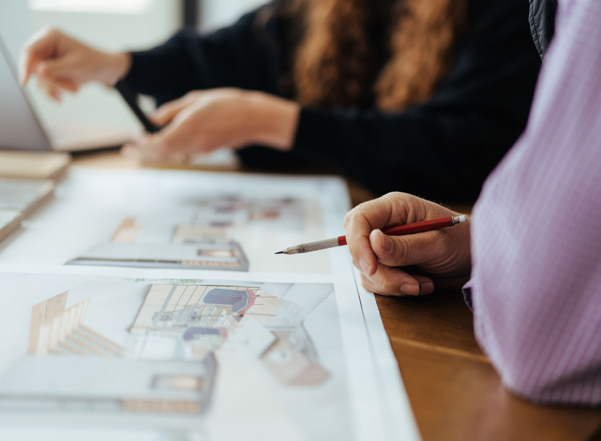 two people working on architectural drawing