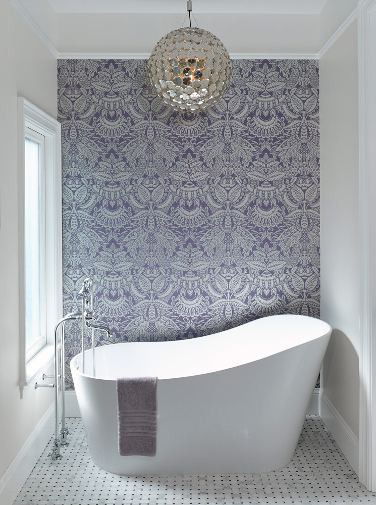 White freestanding tub with victorian wallpaper and mirrored pendant