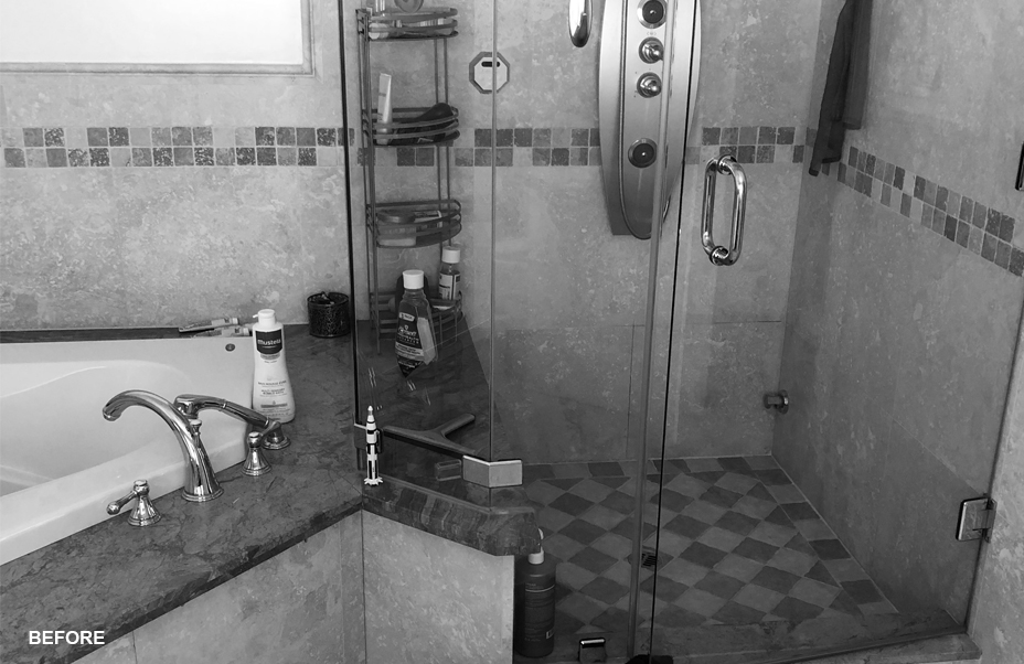 A dated bathroom with dark tiles and fixtures.