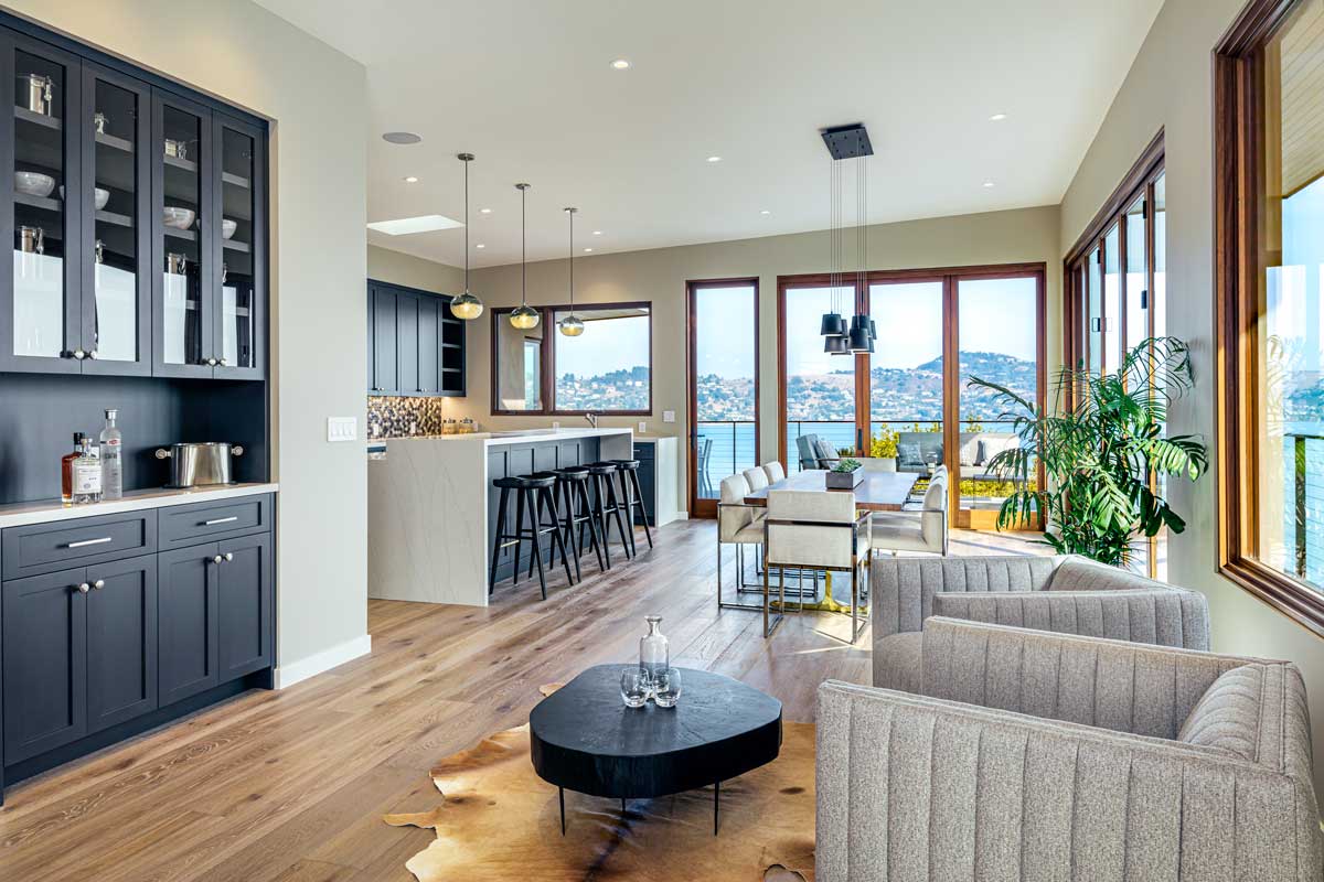 Open Plan Kitchen and Dining room with Accordion Doors Opening to Deck